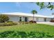 Charming home featuring a well-manicured lawn, vibrant landscaping, and a white tile roof at 6524 11Th W Ave # 5611, Bradenton, FL 34209