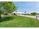 Charming home featuring a well-manicured lawn, vibrant landscaping, and a white tile roof at 6524 11Th W Ave # 5611, Bradenton, FL 34209
