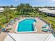 View of the inviting community pool with lounge chairs and beautiful, fenced-in patio space at 6524 11Th W Ave # 5611, Bradenton, FL 34209
