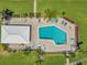 Aerial shot of a bright blue community pool featuring lounge chairs, tables, and manicured landscaping at 6524 11Th W Ave # 5611, Bradenton, FL 34209