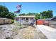 Inviting single-story home with a front porch, American flag, and spacious yard at 6812 E 21St Ave, Tampa, FL 33619