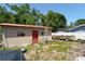 Exterior shot of a storage shed with red door, offering extra space for tools or hobbies at 6812 E 21St Ave, Tampa, FL 33619