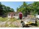 Backyard shed with a red garage door and additional outside storage, perfect for organization at 6812 E 21St Ave, Tampa, FL 33619