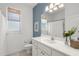 Well-lit bathroom features a large mirror, white vanity, and a blue accent wall at 710 N River Rd, Venice, FL 34293