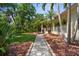 Home featuring a pathway through a landscaped yard and a charming, covered porch at 710 N River Rd, Venice, FL 34293