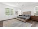 Serene main bedroom featuring soft natural light, neutral colors, and wood-look floors at 710 N River Rd, Venice, FL 34293