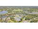 High angle view showcasing a community with tennis courts, pools, and a serene lake at 7303 Westminster Ct, University Park, FL 34201