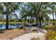 Scenic backyard with a brick patio, bench seating, and water views at 7303 Westminster Ct, University Park, FL 34201