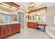 Luxurious bathroom boasts dual vanities, custom cabinets, chandelier, and a decorative tile floor at 7303 Westminster Ct, University Park, FL 34201