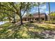 Lush, green backyard view of the home with screened-in lanai at 7303 Westminster Ct, University Park, FL 34201