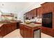 Well-appointed kitchen featuring stainless steel appliances, granite counters, an island, and wood cabinetry at 7303 Westminster Ct, University Park, FL 34201
