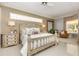 Serene main bedroom with a detailed carved bed frame, natural light, and a cozy seating area at 7303 Westminster Ct, University Park, FL 34201