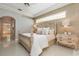 Serene main bedroom offers an ornate headboard, soft lighting, and access to an ensuite bathroom at 7303 Westminster Ct, University Park, FL 34201