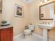 Elegant powder room with pedestal sink, framed art, and decorative wallpaper for a touch of classic charm at 7303 Westminster Ct, University Park, FL 34201