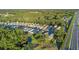 Scenic aerial view of a residential community with lush greenery, pond, and nearby road at 7519 Berna Ln, Land O Lakes, FL 34637