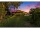 A well-maintained backyard features a screened-in patio, lush lawn, and privacy hedges at 7519 Berna Ln, Land O Lakes, FL 34637