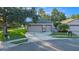 Charming single-story home with a two-car garage, concrete driveway, and manicured lawn at 7519 Berna Ln, Land O Lakes, FL 34637