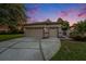Three-car garage with a concrete driveway and manicured lawn offers ample parking and curb appeal at 7519 Berna Ln, Land O Lakes, FL 34637