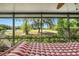 Covered patio with a hammock and scenic golf course view beyond manicured landscaping at 7519 Berna Ln, Land O Lakes, FL 34637