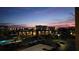 Community view with condo buildings, swimming pool, parking, and palm trees against a twilight sky at 7700 Sun Island S Dr # 506, South Pasadena, FL 33707