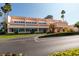 Exterior view of a two-story commercial building featuring well-maintained landscaping and ample parking at 7700 Sun Island S Dr # 506, South Pasadena, FL 33707