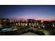 View of the community including the pool, residential buildings, and palm trees at dusk at 7700 Sun Island S Dr # 506, South Pasadena, FL 33707