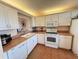 Well-lit kitchen featuring white cabinets, countertops, and appliances at 7700 Sun Island S Dr # 506, South Pasadena, FL 33707