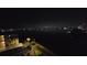 Scenic night view featuring a waterway, city lights, and palm trees silhouetted against the dark sky at 7700 Sun Island S Dr # 506, South Pasadena, FL 33707