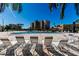 Inviting outdoor pool with ample lounge chairs set under palm trees and blue skies at 7700 Sun Island S Dr # 506, South Pasadena, FL 33707