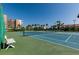 A blue and green tennis court is surrounded by palms and meticulously kept grounds at 7700 Sun Island S Dr # 506, South Pasadena, FL 33707
