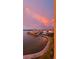 Scenic waterfront view featuring a calm bay, condos with covered parking, and a beautiful sunset sky at 7700 Sun Island S Dr # 506, South Pasadena, FL 33707