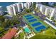 An aerial view shows several well-maintained tennis courts with green and blue surfaces between condos at 7872 Sailboat Key S Blvd # 602, South Pasadena, FL 33707