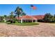 Well-manicured entryway featuring red brick drive, lush green landscaping, and an American flag at 7872 Sailboat Key S Blvd # 602, South Pasadena, FL 33707