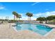 Community swimming pool surrounded by a fence, lounge chairs, and shade trees at 7872 Sailboat Key S Blvd # 602, South Pasadena, FL 33707