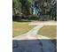 This yard features a concrete patio area, a grassy section, and trees that provide ample shade at 816 Drane Nw St, Plant City, FL 33563