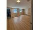 Large room with wood floors, two windows, and a door leading to a bathroom at 816 Drane Nw St, Plant City, FL 33563