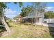 A spacious backyard featuring a covered patio, lush greenery, and mature trees on a sunny day at 8212 Malvern Cir, Tampa, FL 33634
