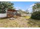 Large backyard featuring a deck, partial fencing, and mature trees at 8212 Malvern Cir, Tampa, FL 33634