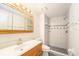 Bright bathroom featuring a tiled walk-in shower and updated vanity with sink at 8212 Malvern Cir, Tampa, FL 33634