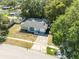 Aerial view of charming single-story home with mature trees and a well-maintained lawn at 834 Anchorage Ln, Palm Harbor, FL 34685
