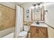 Bathroom featuring a bathtub, toilet, vanity, and decorative elements with earth-toned tiling and coastal decor at 8706 Driftwood Dr, Tampa, FL 33615