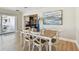 Dining area with wooden table, seating for six and an abstract painting with sliding doors to outdoor patio at 8706 Driftwood Dr, Tampa, FL 33615