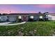 Charming single story home with a well manicured lawn, and a bright pink front door at 8706 Driftwood Dr, Tampa, FL 33615