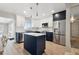 Modern kitchen with white cabinets, navy island, stainless steel appliances, and wood flooring at 8706 Driftwood Dr, Tampa, FL 33615