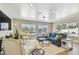 Bright living room showcasing a blue sofa, neutral armchairs, and large windows offering relaxing outdoor views at 8706 Driftwood Dr, Tampa, FL 33615