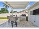 Outdoor grill station with countertop seating area under a covered patio at 8706 Driftwood Dr, Tampa, FL 33615