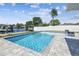 A clear blue pool surrounded by pavers, landscaping, and a view of the canal at 8706 Driftwood Dr, Tampa, FL 33615