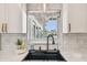Close-up of the kitchen sink featuring modern fixtures and a window that brings in natural light and backyard views at 8706 Driftwood Dr, Tampa, FL 33615