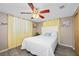 Bright bedroom with ceiling fan, wood-look flooring, and sunny yellow curtains at 9086 Enchantment Dr, Largo, FL 33773