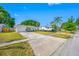 Single-story home with a well-manicured lawn and an RV parked in the driveway at 9086 Enchantment Dr, Largo, FL 33773